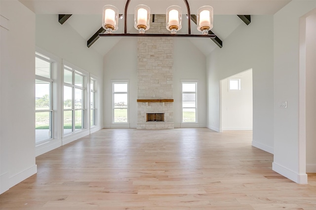 unfurnished living room featuring a healthy amount of sunlight, light hardwood / wood-style flooring, and high vaulted ceiling