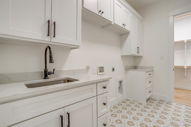 clothes washing area with hookup for an electric dryer, light tile patterned floors, hookup for a washing machine, cabinets, and sink