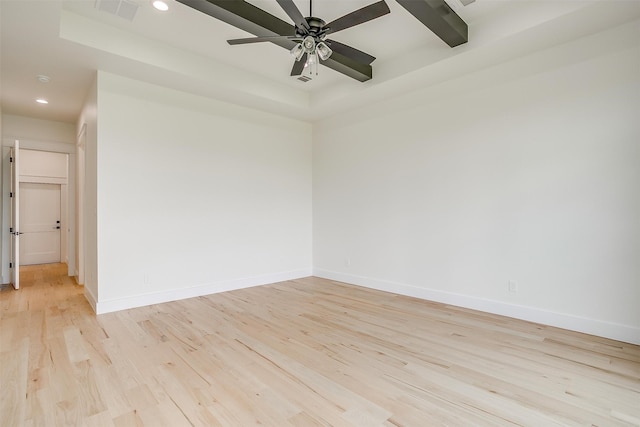 spare room featuring ceiling fan, light hardwood / wood-style flooring, and a raised ceiling