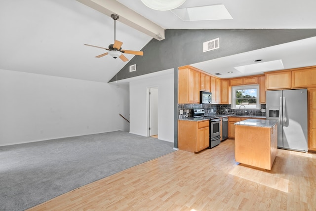 kitchen with a kitchen island, light wood-type flooring, stainless steel appliances, and a skylight