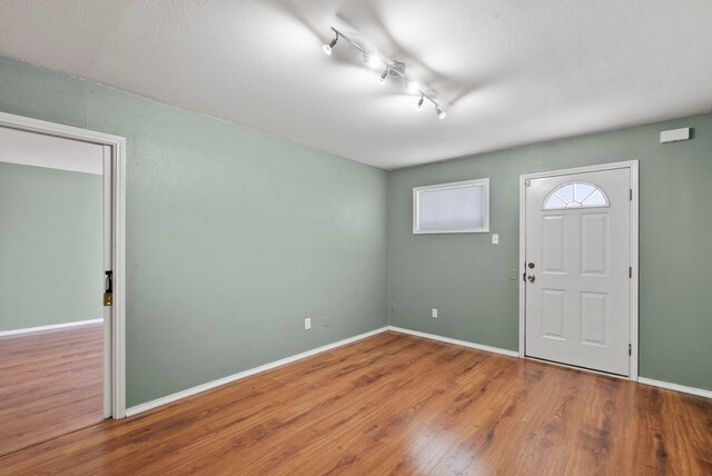 entrance foyer featuring track lighting and hardwood / wood-style flooring