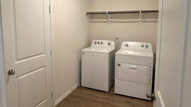 clothes washing area featuring dark wood-type flooring and washing machine and clothes dryer