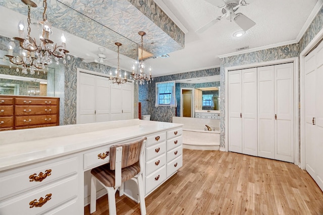 bathroom featuring hardwood / wood-style flooring, a tub, a textured ceiling, ornamental molding, and ceiling fan with notable chandelier