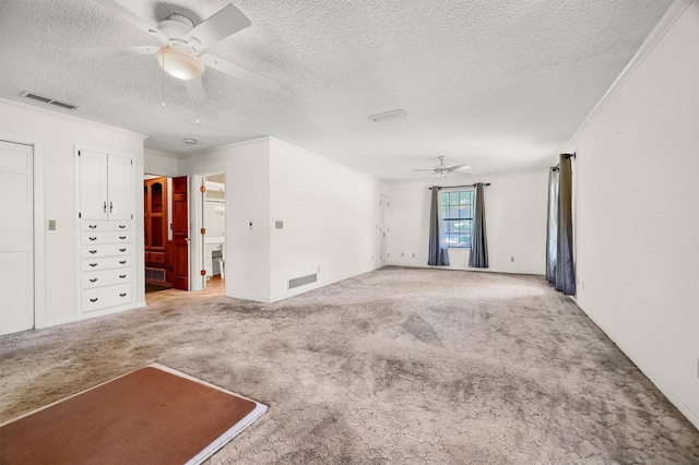 unfurnished room with ceiling fan, light colored carpet, a textured ceiling, and ornamental molding