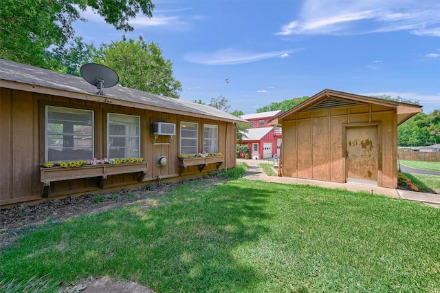 view of yard featuring a wall mounted AC and a storage unit