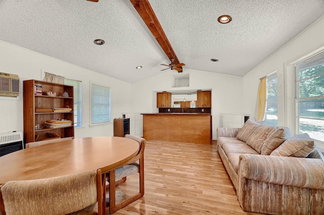 dining space featuring ceiling fan, lofted ceiling with beams, a textured ceiling, and light hardwood / wood-style floors