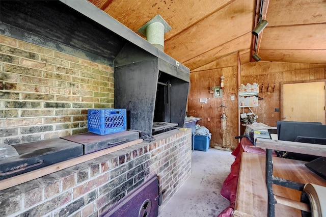 interior space with concrete floors, lofted ceiling, and wooden walls