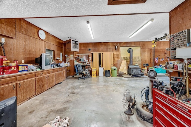 garage with a wood stove and wood walls