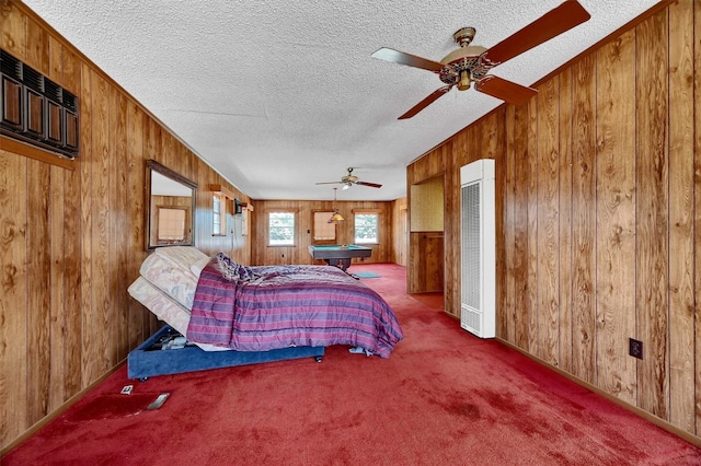 bedroom with ceiling fan, wooden walls, a textured ceiling, and carpet flooring