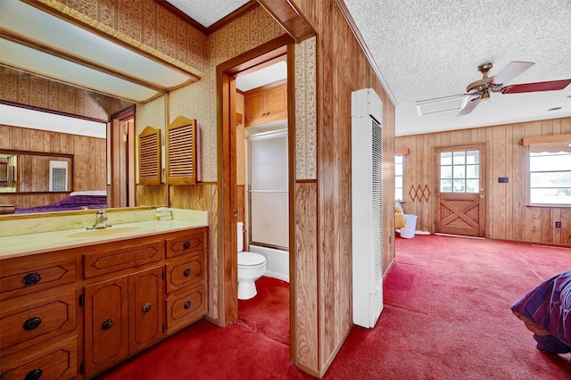 full bathroom featuring ceiling fan, bath / shower combo with glass door, and wooden walls