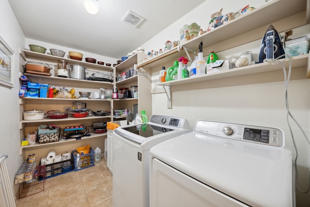 washroom featuring light tile patterned flooring and washing machine and clothes dryer