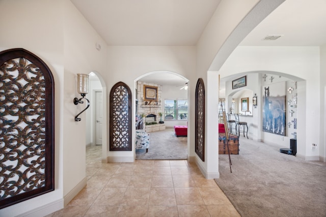 foyer featuring a fireplace and light carpet