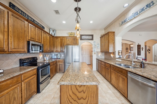 kitchen featuring pendant lighting, sink, crown molding, appliances with stainless steel finishes, and a kitchen island