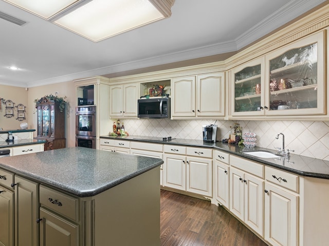 kitchen featuring a center island, stainless steel appliances, dark wood-type flooring, sink, and cream cabinetry