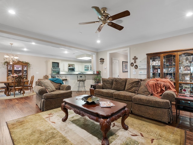 living room featuring ceiling fan with notable chandelier, light hardwood / wood-style flooring, and crown molding