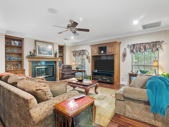 living room with wood-type flooring, crown molding, and ceiling fan