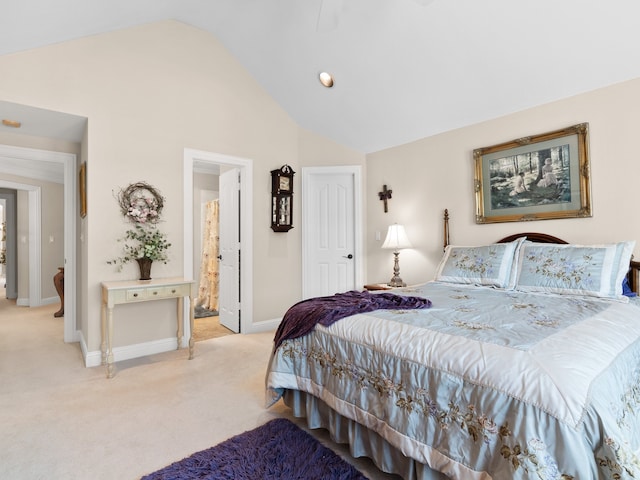 carpeted bedroom featuring vaulted ceiling and connected bathroom