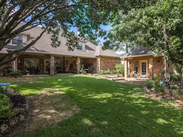 rear view of property featuring a patio and a yard