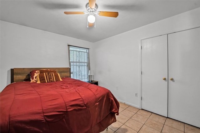 bedroom with ceiling fan, light tile patterned floors, and a closet