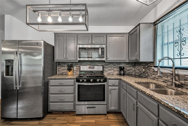 kitchen featuring sink, backsplash, appliances with stainless steel finishes, and stone counters