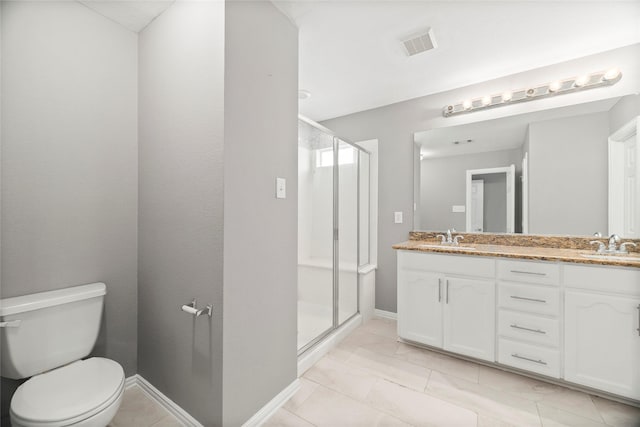 bathroom with tile patterned floors, vanity, an enclosed shower, and toilet