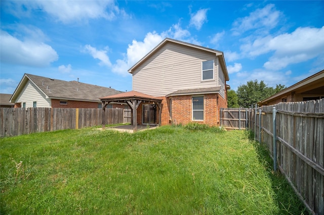 back of property with a gazebo and a yard