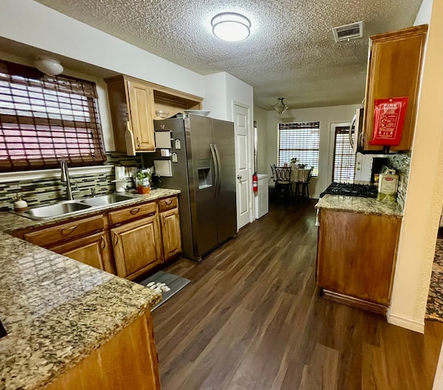 kitchen featuring a textured ceiling, dark hardwood / wood-style flooring, stainless steel fridge with ice dispenser, and sink