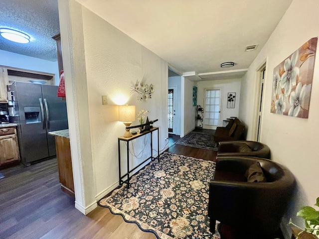 hallway with dark hardwood / wood-style floors and a textured ceiling