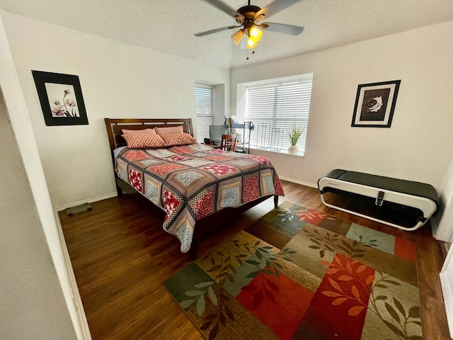 bedroom with ceiling fan, dark hardwood / wood-style flooring, and a textured ceiling