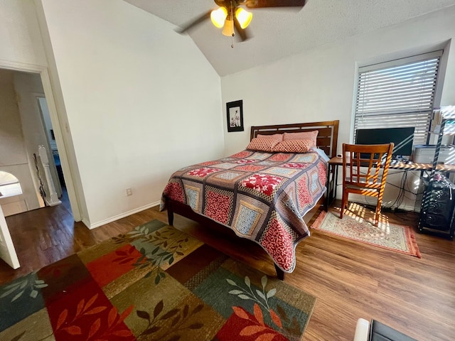 bedroom featuring hardwood / wood-style floors, ceiling fan, a textured ceiling, and vaulted ceiling