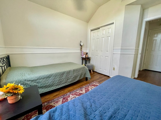 bedroom featuring lofted ceiling, a closet, and dark hardwood / wood-style floors