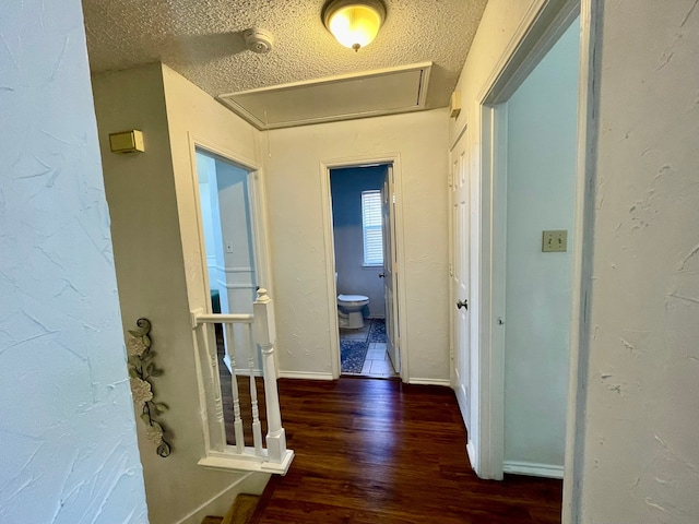 hallway featuring a textured ceiling and dark hardwood / wood-style floors