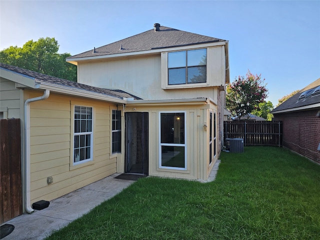 back of house featuring a lawn and central AC unit