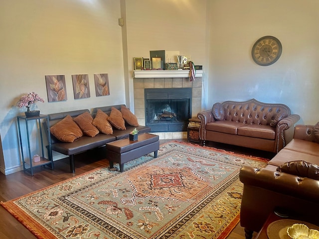 living room with a tile fireplace and dark hardwood / wood-style flooring