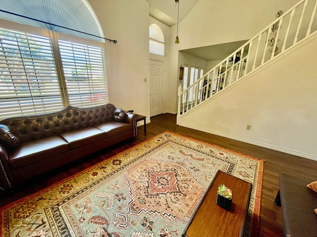 living room with dark wood-type flooring and a high ceiling