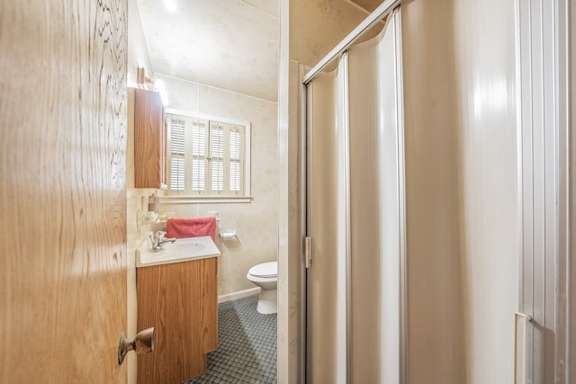 bathroom with tile patterned floors, toilet, a shower with door, and vanity