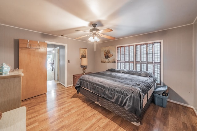 bedroom with ornamental molding, light hardwood / wood-style flooring, and ceiling fan