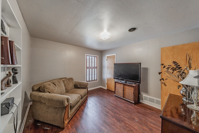 living room with a textured ceiling and dark hardwood / wood-style floors