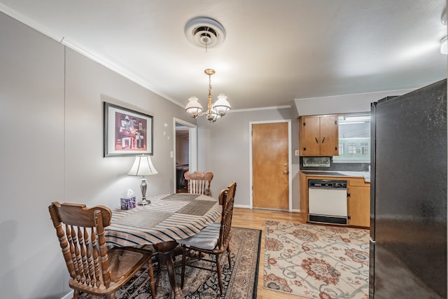 dining area featuring ornamental molding, an inviting chandelier, and light hardwood / wood-style floors