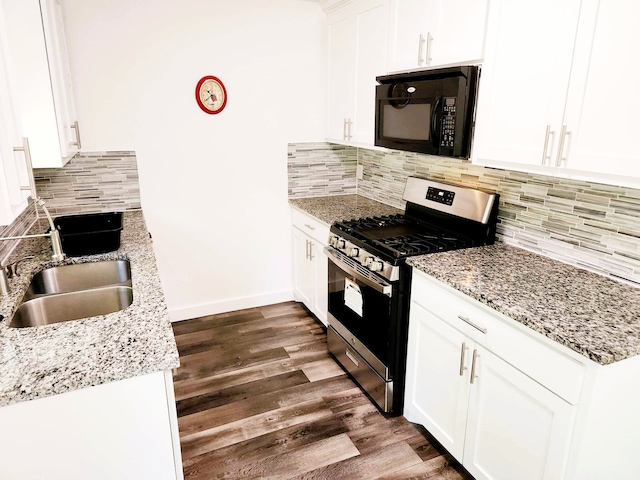 kitchen with dark hardwood / wood-style floors, tasteful backsplash, white cabinetry, and gas range