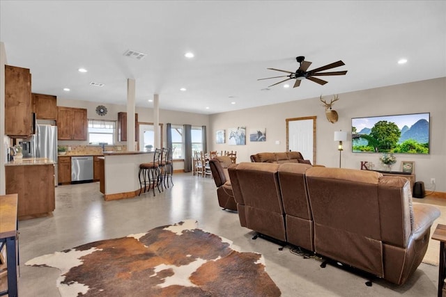 living room with recessed lighting, visible vents, and finished concrete flooring