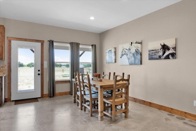 dining room featuring baseboards, recessed lighting, finished concrete flooring, and a healthy amount of sunlight