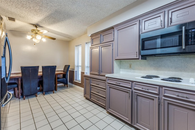 kitchen with visible vents, ceiling fan, stainless steel microwave, gray cabinets, and light countertops