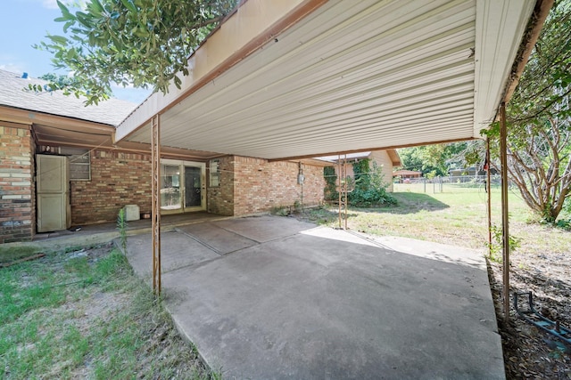 view of patio featuring fence and a carport