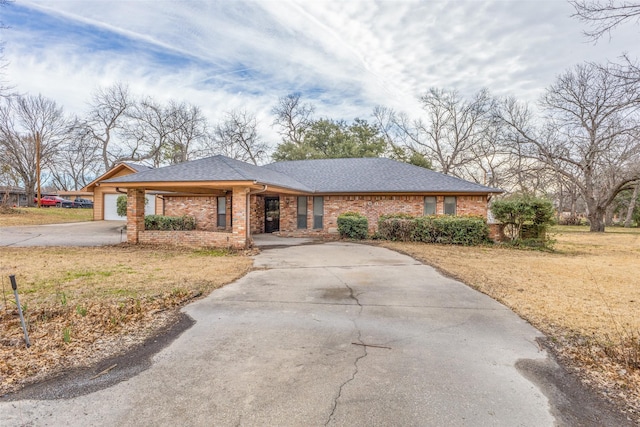 view of front of house with a garage, brick siding, a shingled roof, concrete driveway, and a front yard