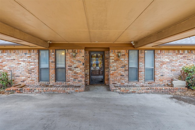 doorway to property with brick siding