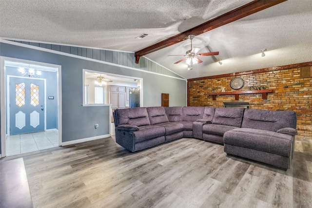 living room with vaulted ceiling with beams, a textured ceiling, and wood finished floors