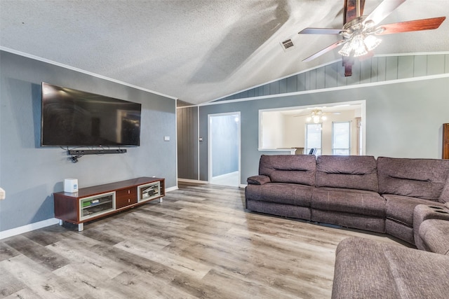 living room with lofted ceiling, a textured ceiling, visible vents, and wood finished floors