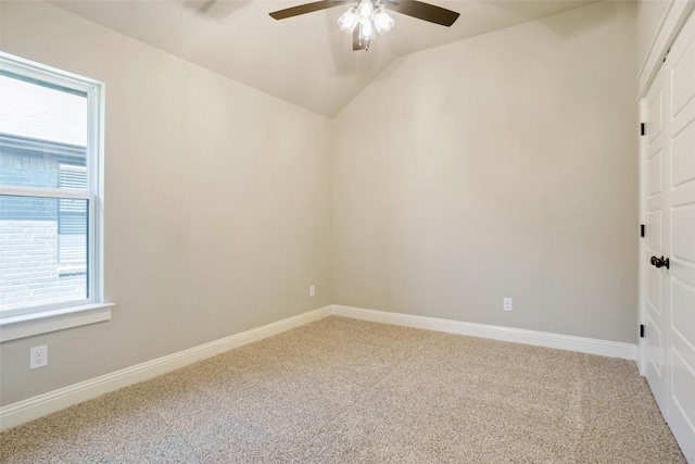 empty room featuring vaulted ceiling, carpet flooring, and ceiling fan