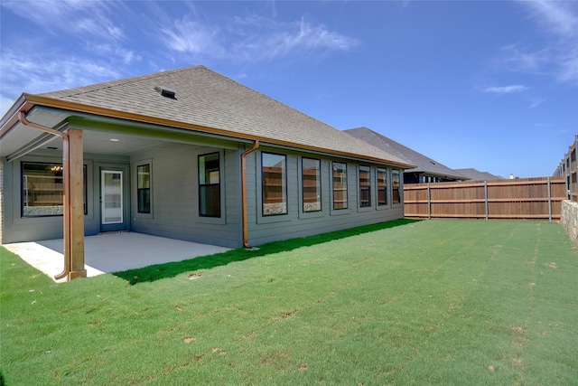 rear view of house with a patio area and a lawn